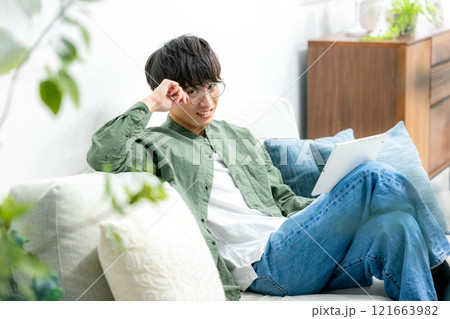 リビングでくつろぐ男性 タブレット リビングでくつろぐ男性 タブレット 121663982