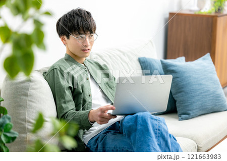自宅でパソコンを使う若い男性 121663983