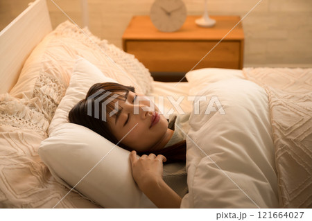 間接照明で眠りにつく女性 ベッドの睡眠や安眠のイメージの横顔 間接照明で眠りにつく女性 ベッドの睡眠や安眠のイメージの横顔 121664027