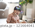 Asian cheerful young boy with Down syndrome enjoys playing with bubbles indoors. His bright smile and playful gestures capture the innocence and joy of childhood 121664041