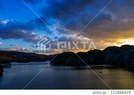 新春の奈良布目ダム寒風吹きすさぶ夕景　紺色の空と黄金色の夕焼けの美しい対比 121666029