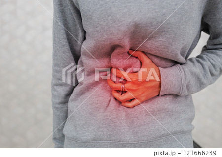 woman hand touching abdomen having stomach ache, female eating food poisoning causes flatulence, digestive disease, Abdominal pain during menstruation. 121666239