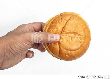 Hand holding a fresh butter bun on a white background, close-up Hand holding a fresh butter bun on a white background, close-up 121667957