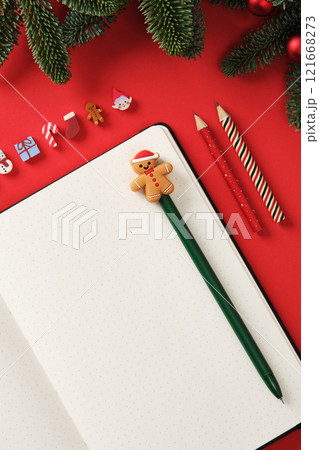 Flat Lay Christmas writing with open notepad and festive pencils on a red background with fir branches. Place for Your Text. 121668273
