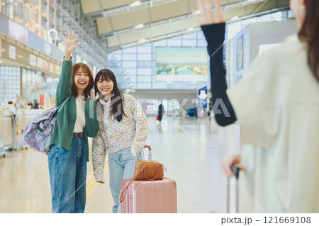 空港にきた友達を迎える女性 121669108