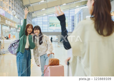 空港にきた友達を迎える女性 空港にきた友達を迎える女性 121669109