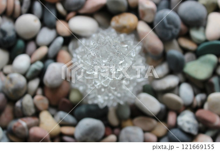 Clear Crystal In Flower Shape On Colored Pebbles Top View Stock Photo For Stones Backgrounds 121669155