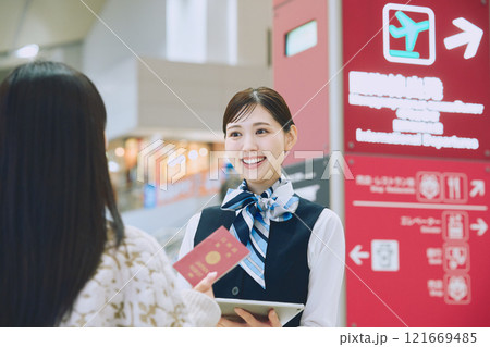 空港でグランドスタッフの案内を受ける女性 121669485