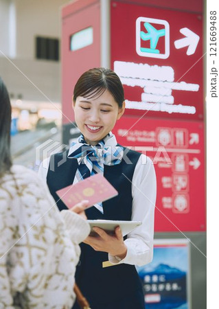 空港でグランドスタッフの案内を受ける女性 空港でグランドスタッフの案内を受ける女性 121669488