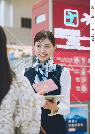 空港でグランドスタッフの案内を受ける女性 121669489