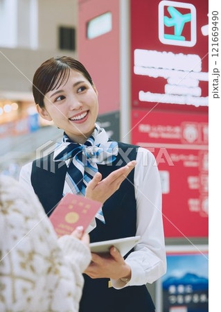 空港でグランドスタッフの案内を受ける女性 空港でグランドスタッフの案内を受ける女性 121669490