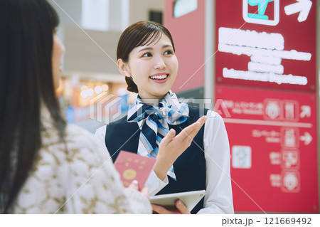 空港でグランドスタッフの案内を受ける女性 空港でグランドスタッフの案内を受ける女性 121669492