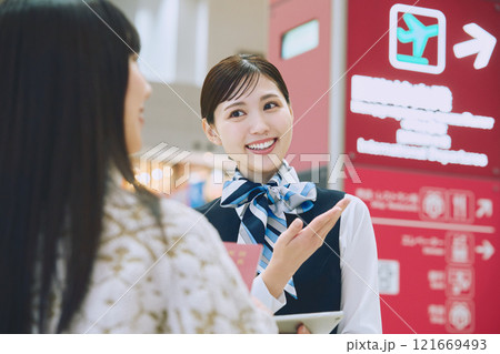 空港でグランドスタッフの案内を受ける女性 121669493