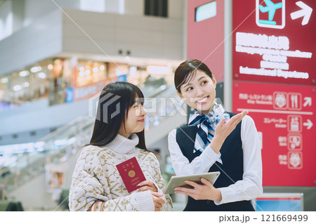 空港でグランドスタッフの案内を受ける女性 121669499