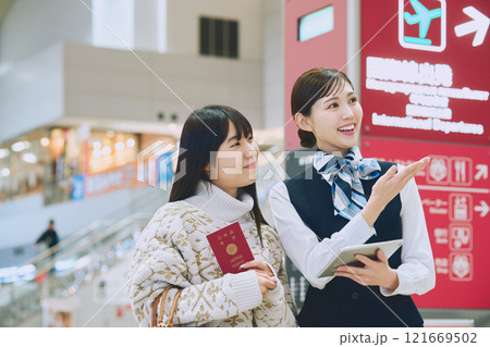 空港でグランドスタッフの案内を受ける女性 121669502