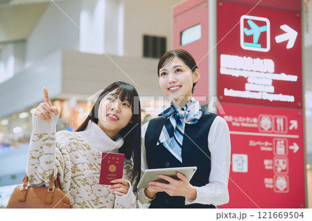 空港でグランドスタッフの案内を受ける女性 121669504