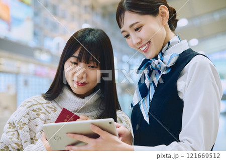 空港でグランドスタッフの案内を受ける女性 空港でグランドスタッフの案内を受ける女性 121669512