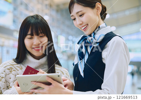 空港でグランドスタッフの案内を受ける女性 空港でグランドスタッフの案内を受ける女性 121669513