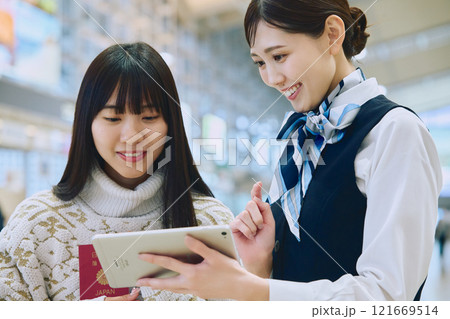 空港でグランドスタッフの案内を受ける女性 空港でグランドスタッフの案内を受ける女性 121669514