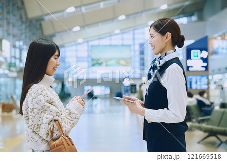 空港でグランドスタッフの案内を受ける女性 空港でグランドスタッフの案内を受ける女性 121669518