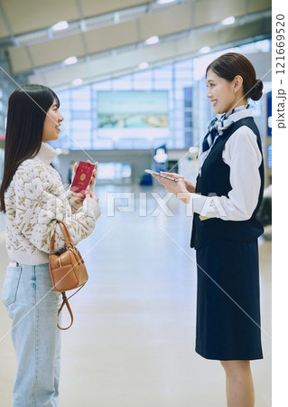 空港でグランドスタッフの案内を受ける女性 121669520