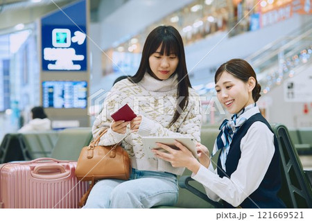 空港でグランドスタッフの案内を受ける女性 121669521