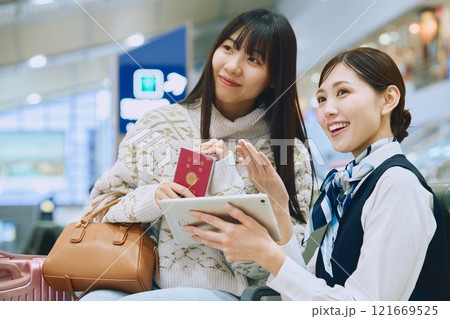 空港でグランドスタッフの案内を受ける女性 空港でグランドスタッフの案内を受ける女性 121669525