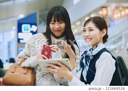 空港でグランドスタッフの案内を受ける女性 121669526