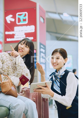 空港でグランドスタッフの案内を受ける女性 空港でグランドスタッフの案内を受ける女性 121669533