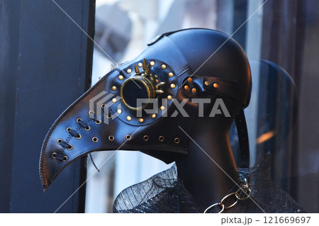 A masked mannequin plague doctor in shop window, closeup of headgear A masked mannequin plague doctor in shop window, closeup of headgear 121669697