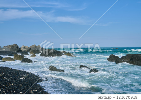 青空と波しぶきが美しい岩場の海岸風景 121670919