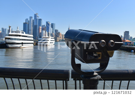 Coin operated binoculars, view of the skyscrapers of Manhattan and big yachts from the water, New York landscape from the waterfront 121671032