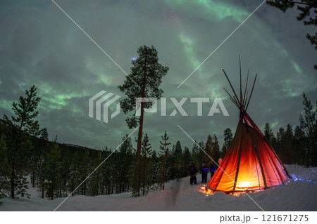 Sami tent with Northern Lights in Lapland Inari Nellin Lake forest 121671275