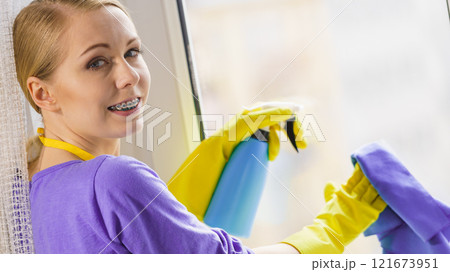 Girl cleaning window at home Girl cleaning window at home 121673951