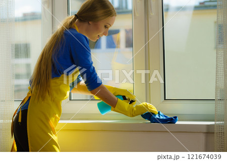 Woman cleaning windowsill 121674039