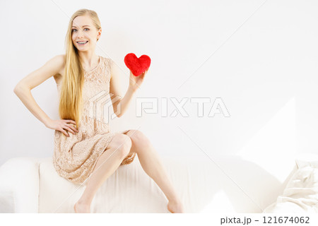 Happy young woman holding red heart Happy young woman holding red heart 121674062