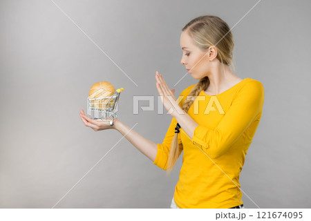 Woman holding shopping cart with bread 121674095