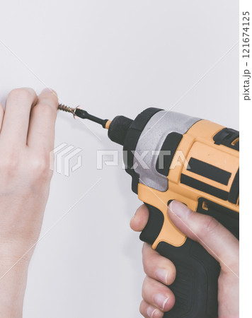 Person drilling in wall 121674125