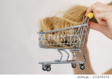 Girl with her long hair in shopping cart Girl with her long hair in shopping cart 121676174