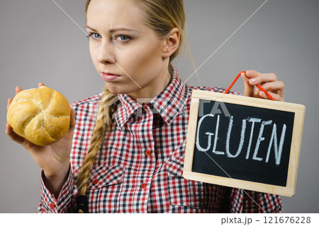 Woman holding board with gluten sign and bun bread 121676228