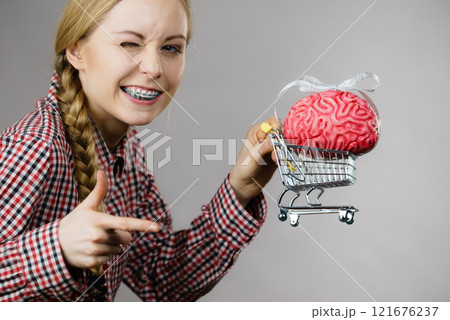 Woman holding shopping cart with brain 121676237