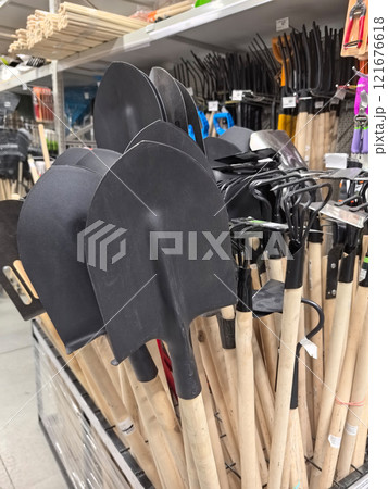 Garden tools lined up for selection in a bright retail store space Garden tools lined up for selection in a bright retail store space 121676618
