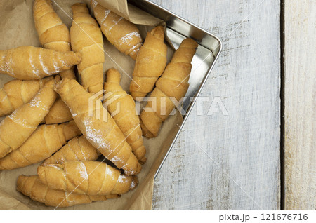 Croissant and cup of hot drink on white table in kitchen, space for text. Freshly baked croissants. Bakery products 121676716