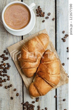 Breakfast with cup of coffee and fresh croissant. Flat lay. Top view. Homemade croissant with black coffee or americano 121677390
