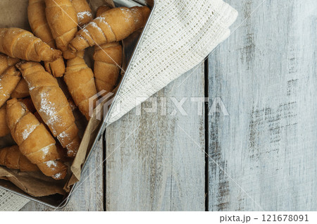 Croissant and cup of hot drink on white table in kitchen, space for text. Freshly baked croissants. Bakery products 121678091
