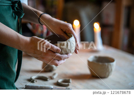 Woman potter sculpting clay pot with hand. Ceramist work with raw earthenware creating craft pottery 121678678
