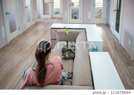 Female employee and cat game with string toy, cat stay as comfortable as possible. Cat toys, comfort 121678694