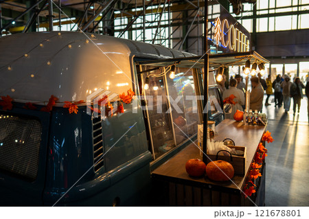 Holiday decorated coffee shop in minibus with pumpkins and fall leaves inside shopping center market Holiday decorated coffee shop in minibus with pumpkins and fall leaves inside shopping center market 121678801