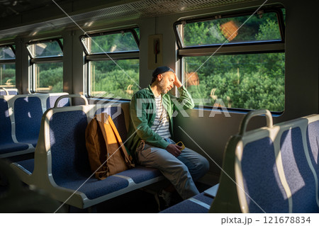 Exhausted man rests in train, catching sleep during commute. Sleep deprivation of overworked male Exhausted man rests in train, catching sleep during commute. Sleep deprivation of overworked male 121678834