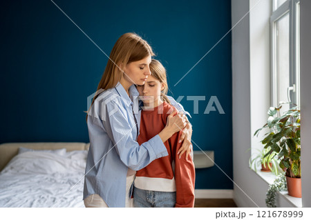 Affectionate empathic young mom tender embracing calming sad upset teen daughter. Affectionate empathic young mom tender embracing calming sad upset teen daughter. 121678999